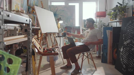 Male-Artist-Video-Calling-on-Laptop-in-Studio
